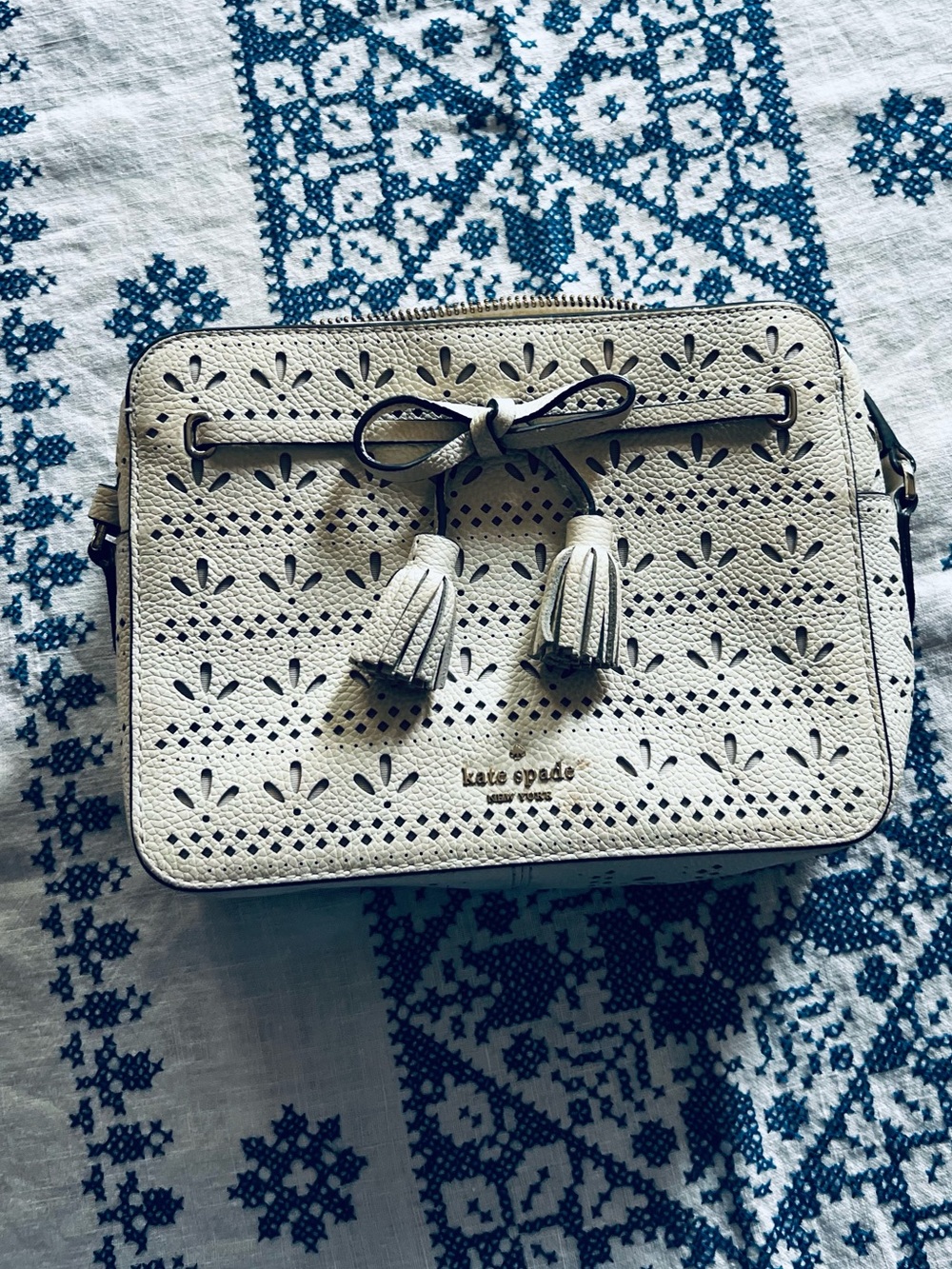 kate spade cream perforated leather crossbody with tassel bow detail